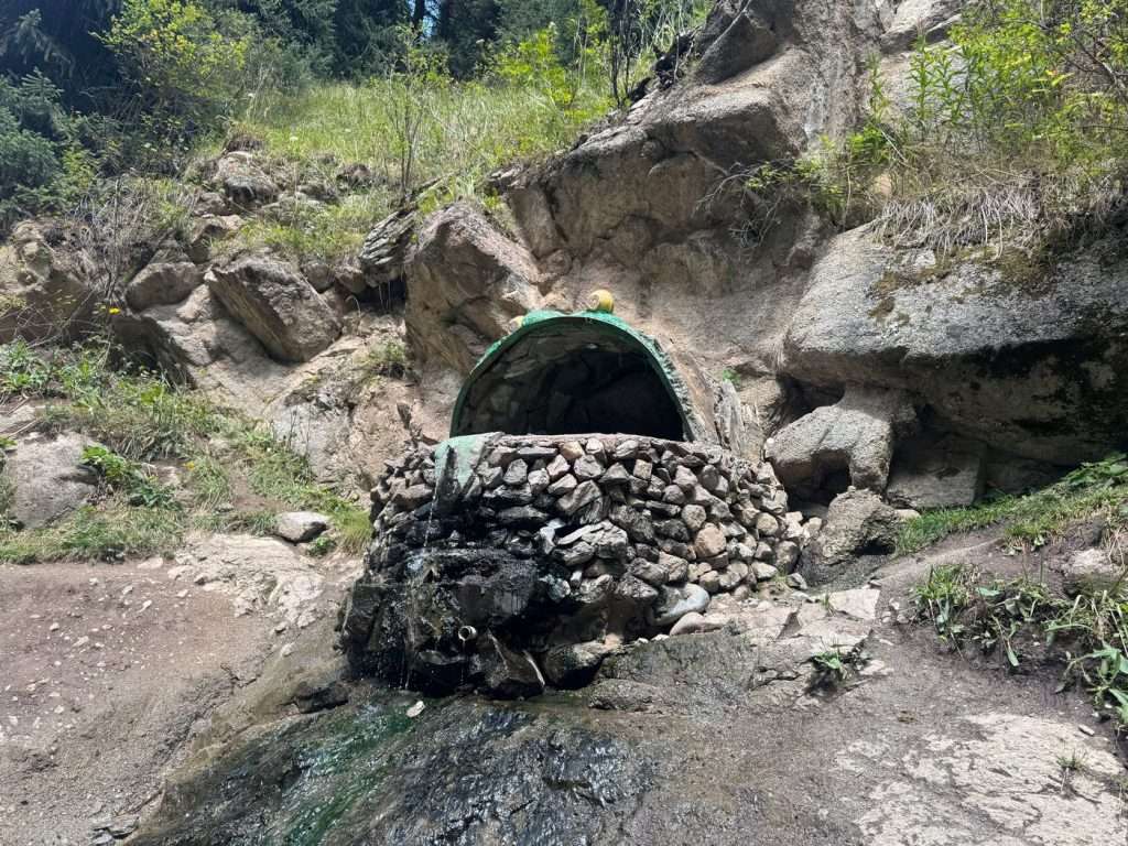 A king frog tub built into the rock shore of the river holds hot spring waters.