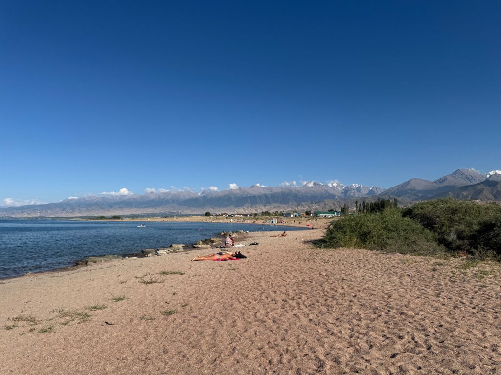 Beach shore of Issyk-Kul from Tosor, with mountains in the background