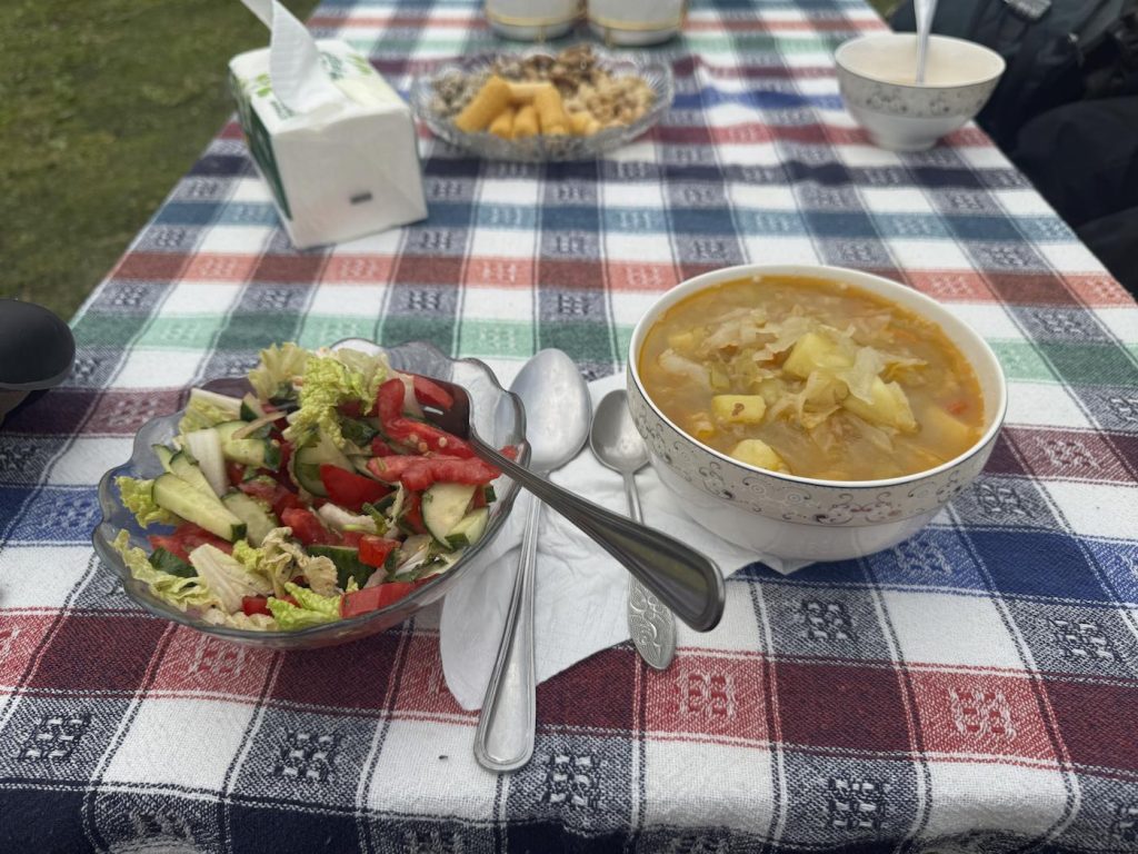 A salad and a hot soup on a table in the outdoors